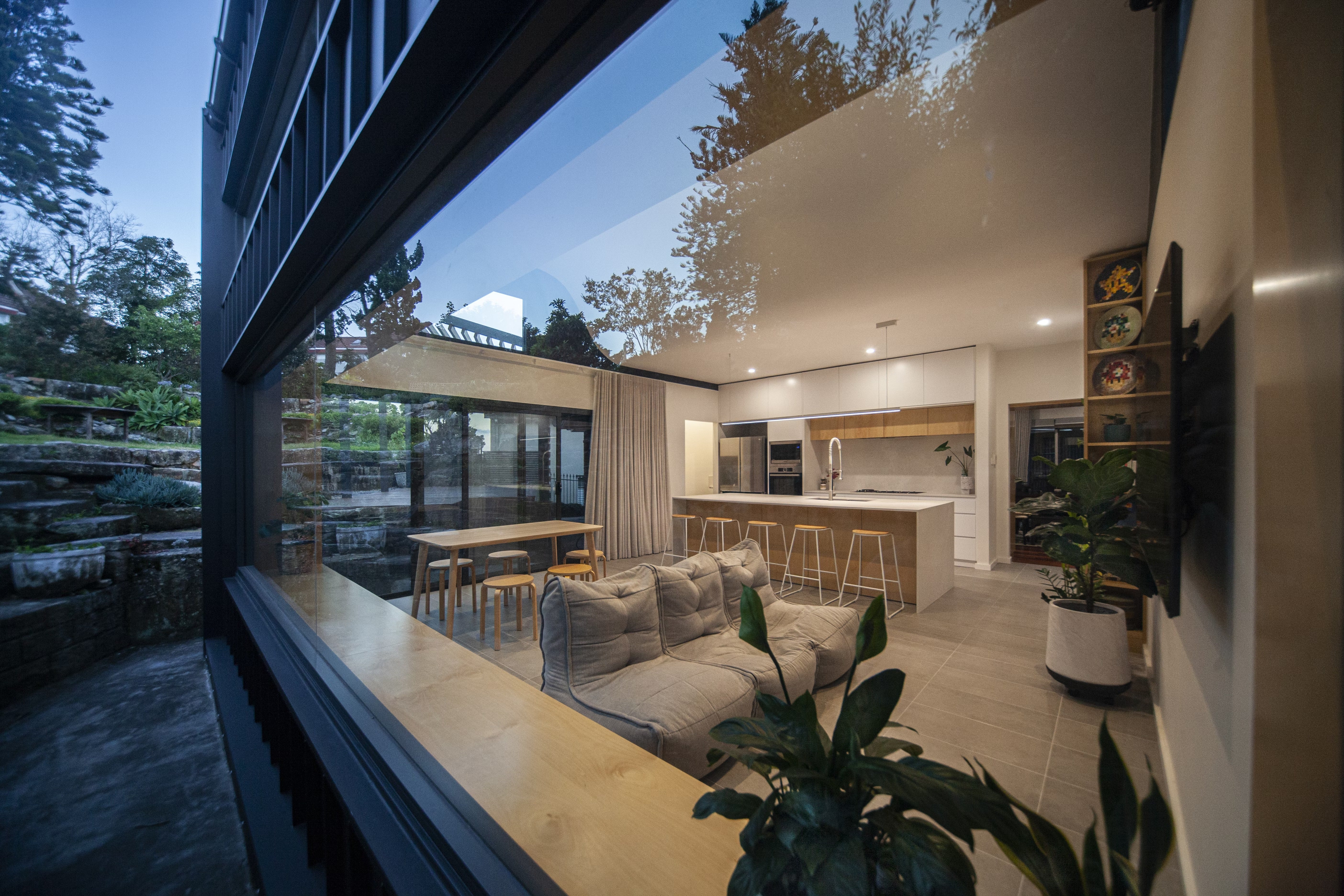 Modular Sofa bean bags in an open-plan living, dining and kitchen space, with large windows overlooking a terraced landscape.