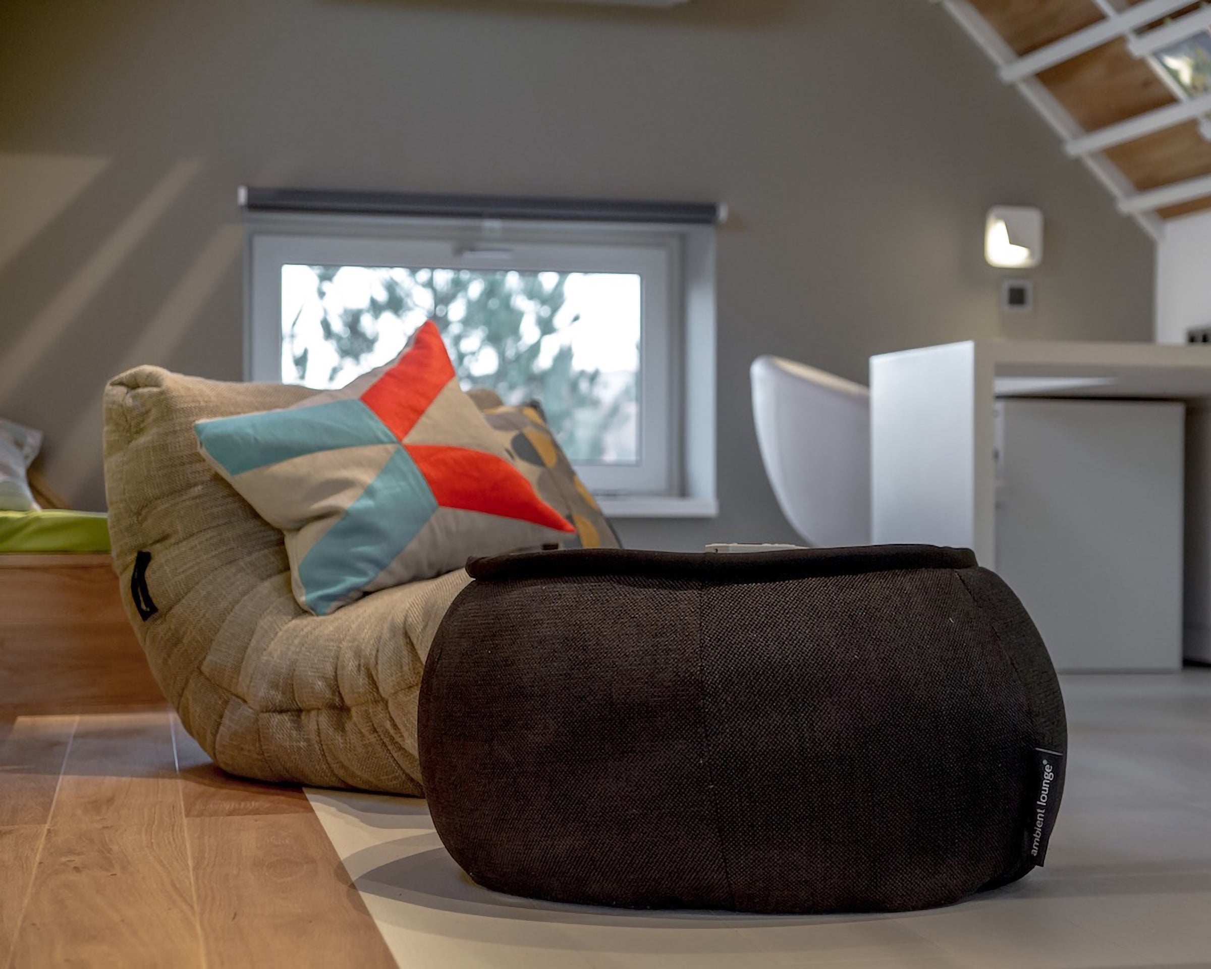 Acoustic Sofa and Versa Table bean bags in a modern attic with a window in the background.