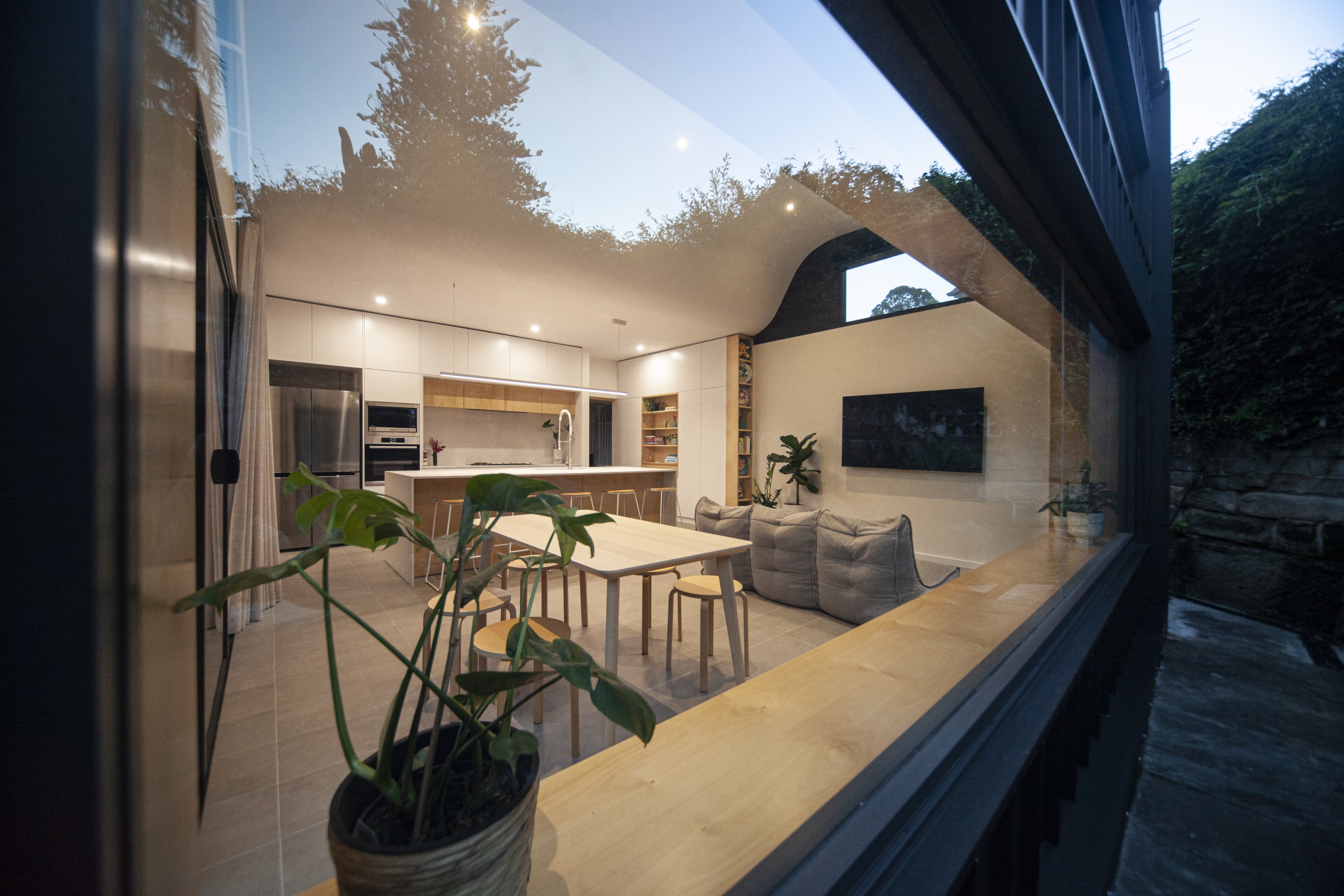 Modern open-plan space with Modular Sofa bean bags in front of wall-mounted TV in living area.